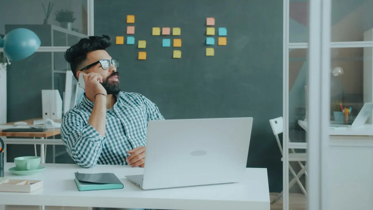 A man on a call at his desk in an office