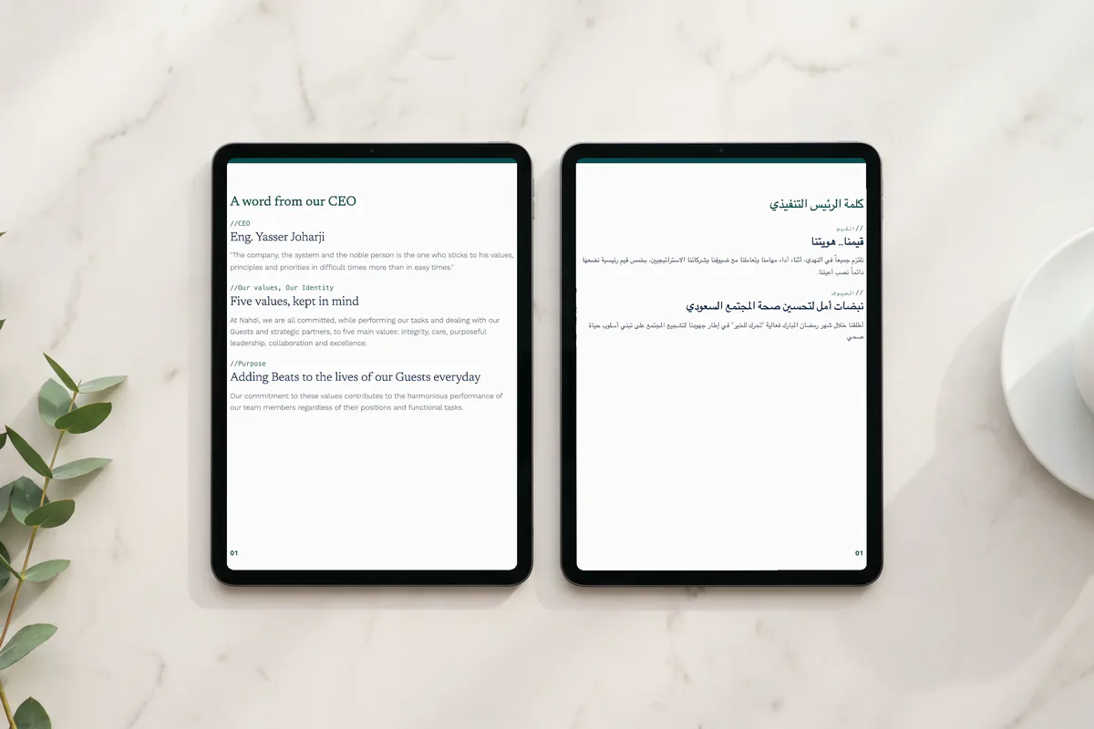 Two tablets on a marble table showing the CEO page of the Al Nahdi newsletter, the English edition on one and the Arabic edition on the other