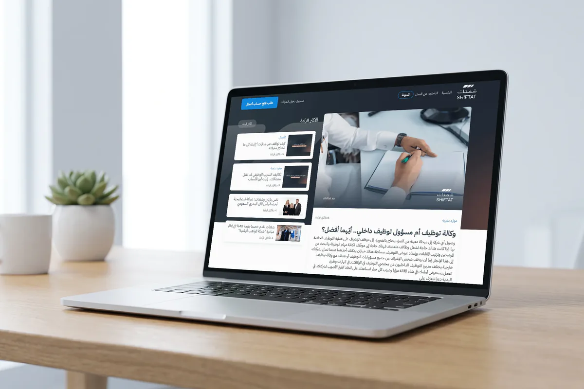 A laptop on a desk showing Shiftat's Arabic blog: the article 'Recruitment agency or in-house recruiter: which is better?' with the most-read list beside it