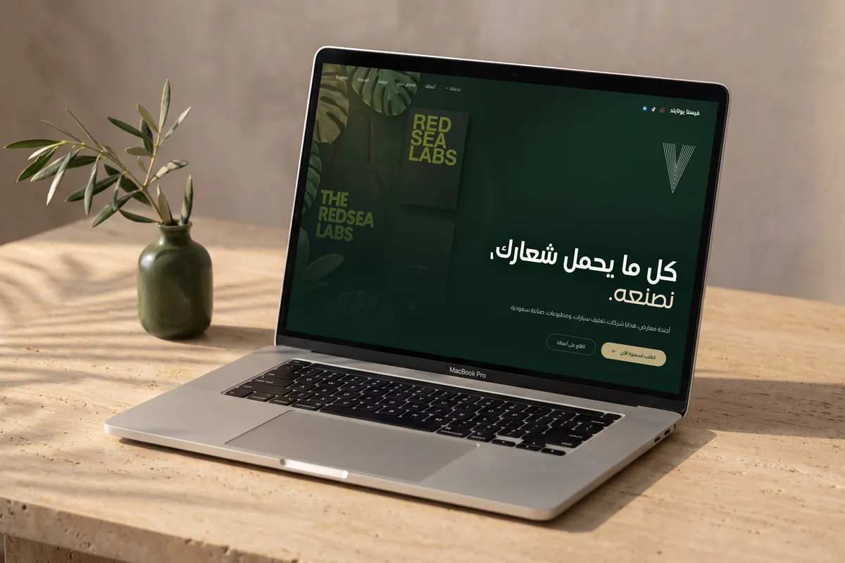A laptop on a table showing the Arabic homepage of Vista United's website.